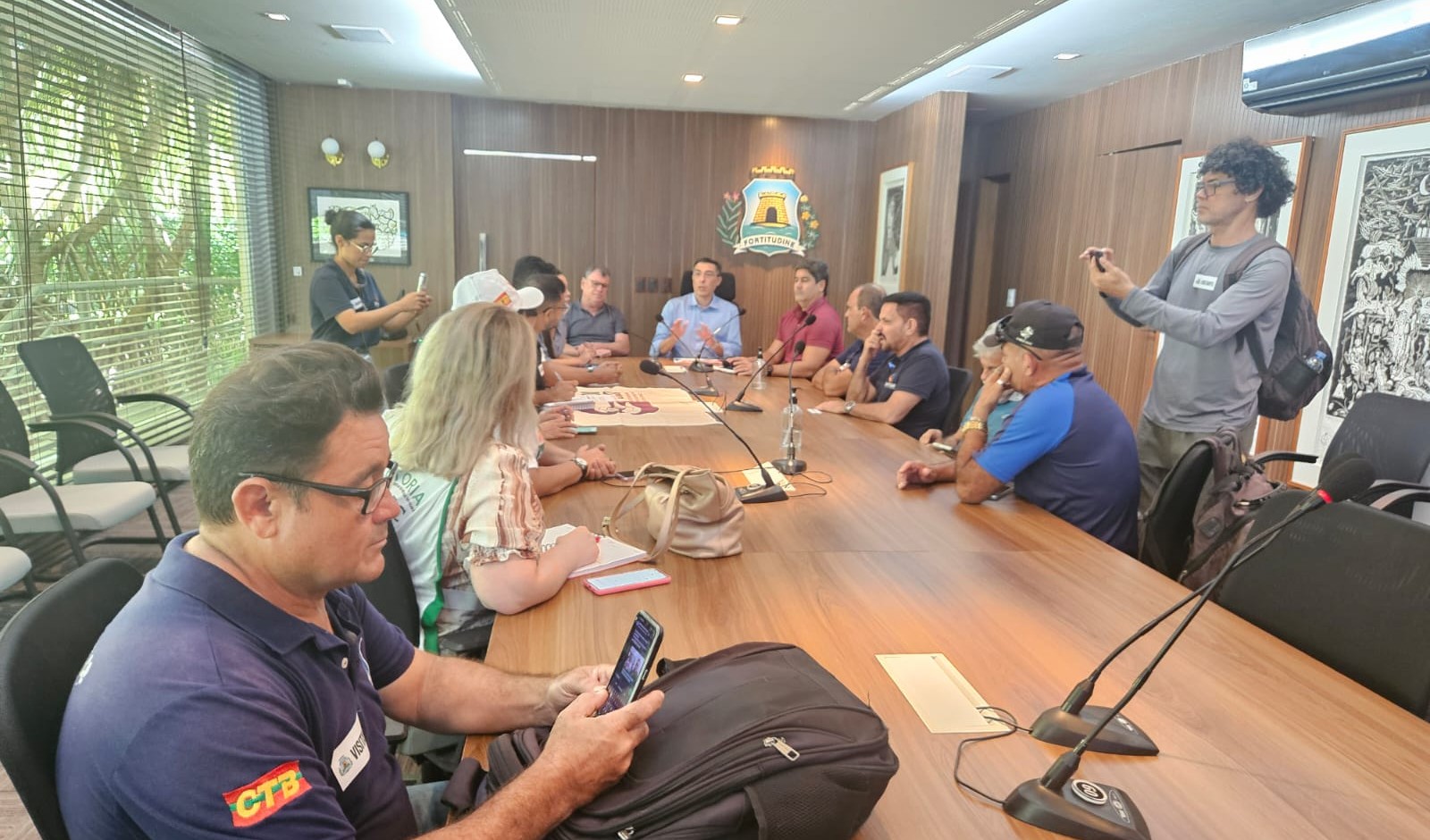 grupo de pessoas na sala de reunião do paço municipal
